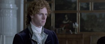 Movie still from “A Royal Affair” (2012), directed by Nikolaj Arcel – A man with curly red hair wearing a black jacket; Close Up shot, Over the shoulder angle