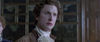 Movie still from “A Royal Affair” (2012), directed by Nikolaj Arcel – A young man in a period costume looking into the distance; Close Up shot, Over the shoulder angle