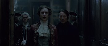 Movie still from “A Royal Affair” (2012), directed by Nikolaj Arcel – Two people standing next to each other in front of a building; Medium shot, Low angle