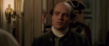 Movie still from “A Royal Affair” (2012), directed by Nikolaj Arcel – A man with a bald head wearing a jacket; Close Up shot, Over the shoulder angle