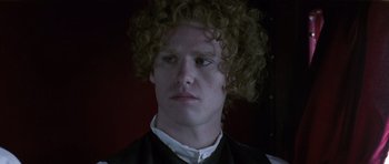 Movie still from “A Royal Affair” (2012), directed by Nikolaj Arcel – A young man with curly blonde hair wearing a vest; Close Up shot, High angle