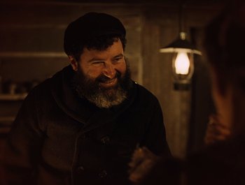 Movie still from “A Serious Man” (2009), directed by Joel Coen – A man with a beard is smiling at the camera; Medium shot, Over the shoulder angle