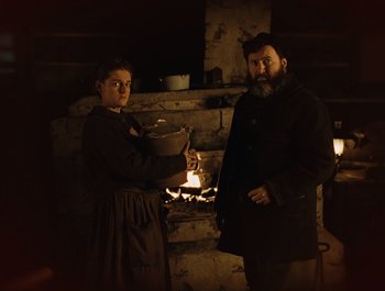 Movie still from “A Serious Man” (2009), directed by Joel Coen – A man and a woman standing in front of a fireplace; Medium shot, Low angle