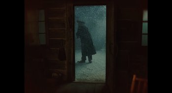 Movie still from “A Serious Man” (2009), directed by Joel Coen – A person standing in a doorway in the snow; Wide shot, Over the shoulder angle