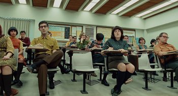 Movie still from “A Serious Man” (2009), directed by Joel Coen – A group of people sitting at desks in a classroom; Wide shot, Low angle