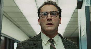 Movie still from “A Serious Man” (2009), directed by Joel Coen – A person wearing a suit and glasses; Close Up shot, Low angle