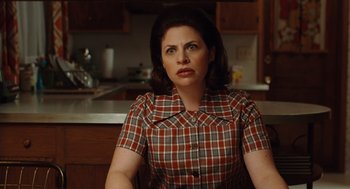 Movie still from “A Serious Man” (2009), directed by Joel Coen – A woman sitting in front of a kitchen counter; Medium shot, Over the shoulder angle