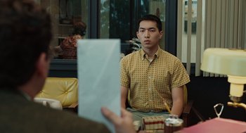 Movie still from “A Serious Man” (2009), directed by Joel Coen – A man sitting in front of another man holding a paper; Medium shot, Over the shoulder angle