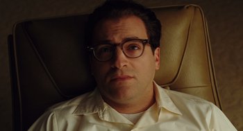 Movie still from “A Serious Man” (2009), directed by Joel Coen – A person wearing glasses and a white shirt; Close Up shot, High angle