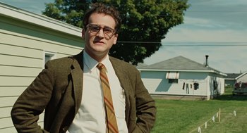 Movie still from “A Serious Man” (2009), directed by Joel Coen – A man in a suit and tie standing in a yard; Medium shot, Low angle