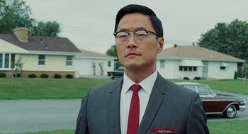 Movie still from “A Serious Man” (2009), directed by Joel Coen – A man in a suit and tie standing in front of a house; Close Up shot, Low angle