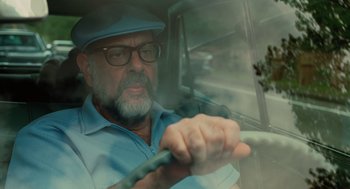 Movie still from “A Serious Man” (2009), directed by Joel Coen – An older man driving a car in the rain; Close Up shot, Over the shoulder angle