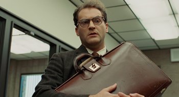 Movie still from “A Serious Man” (2009), directed by Joel Coen – A man in a suit holding a brown briefcase; Close Up shot, Low angle