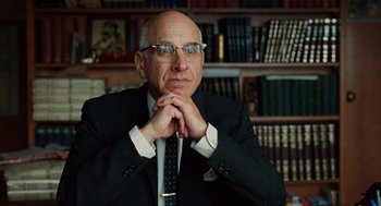 Movie still from “A Serious Man” (2009), directed by Joel Coen – A man in a suit and tie in front of a bookshelf; Close Up shot, Low angle