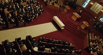 Movie still from “A Serious Man” (2009), directed by Joel Coen – An overhead view of people in a church with a casket; Extreme Wide shot, High angle