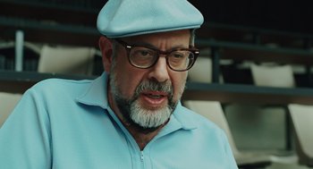 Movie still from “A Serious Man” (2009), directed by Joel Coen – An older man with a beard wearing glasses and a blue hat; Close Up shot, Low angle