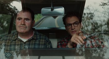 Movie still from “A Serious Man” (2009), directed by Joel Coen – Two men sitting in the back seat of a car; Medium shot, Over the shoulder angle