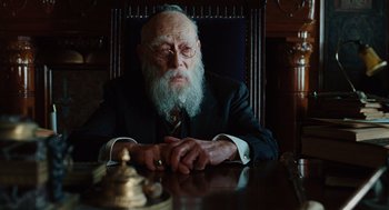 Movie still from “A Serious Man” (2009), directed by Joel Coen – An older man sitting at a table with a beard; Close Up shot, Over the shoulder angle