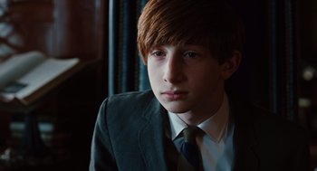 Movie still from “A Serious Man” (2009), directed by Joel Coen – A young man in a suit and tie looking into the distance; Close Up shot, Over the shoulder angle