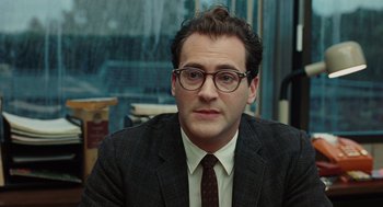 Movie still from “A Serious Man” (2009), directed by Joel Coen – A person wearing glasses and a suit; Close Up shot, Over the shoulder angle