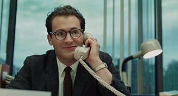 Movie still from “A Serious Man” (2009), directed by Joel Coen – A man in a suit and glasses talking on a phone; Close Up shot, Low angle