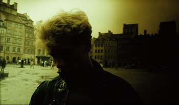 Movie still from “A Short Film About Killing” (1988), directed by Krzysztof Kieslowski – A man standing in the middle of a street; Close Up shot, High angle