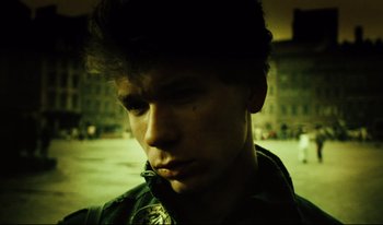 Movie still from “A Short Film About Killing” (1988), directed by Krzysztof Kieslowski – A young man is looking at the camera in the dark; Close Up shot, High angle