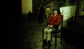 Movie still from “A Short Film About Killing” (1988), directed by Krzysztof Kieslowski – A little girl sitting on a chair in the middle of the street; Wide shot, High angle