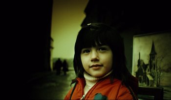 Movie still from “A Short Film About Killing” (1988), directed by Krzysztof Kieslowski – A little girl with long black hair wearing a red jacket; Close Up shot, Low angle