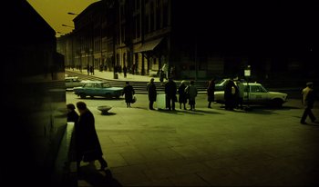 Movie still from “A Short Film About Killing” (1988), directed by Krzysztof Kieslowski – A group of people walking down a street at night; Extreme Wide shot, High angle