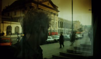 Movie still from “A Short Film About Killing” (1988), directed by Krzysztof Kieslowski – A blurry picture of a person walking down a street; Close Up shot, Low angle