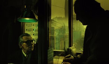 Movie still from “A Short Film About Killing” (1988), directed by Krzysztof Kieslowski – Two men are sitting at a table in front of a window; Medium shot, Over the shoulder angle