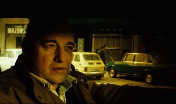 Movie still from “A Short Film About Killing” (1988), directed by Krzysztof Kieslowski – A man is taking a picture of himself in a car; Close Up shot, Low angle