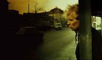 Movie still from “A Short Film About Killing” (1988), directed by Krzysztof Kieslowski – A man looking out of a window at a street; Close Up shot, Low angle