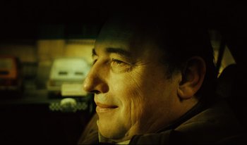Movie still from “A Short Film About Killing” (1988), directed by Krzysztof Kieslowski – A person smiling; Close Up shot, Low angle