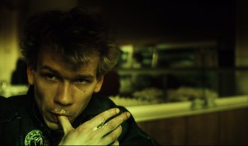 Movie still from “A Short Film About Killing” (1988), directed by Krzysztof Kieslowski – A young man is eating something in the dark; Close Up shot, Low angle