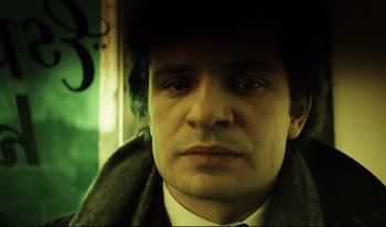 Movie still from “A Short Film About Killing” (1988), directed by Krzysztof Kieslowski – A person wearing a hat and a suit; Close Up shot, Low angle