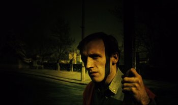 Movie still from “A Short Film About Killing” (1988), directed by Krzysztof Kieslowski – A man standing next to a pole on the side of the street; Close Up shot, Low angle