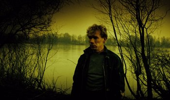 Movie still from “A Short Film About Killing” (1988), directed by Krzysztof Kieslowski – A man standing in front of a body of water; Medium shot, Low angle