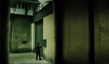 Movie still from “A Short Film About Killing” (1988), directed by Krzysztof Kieslowski – A man walking in front of an open door; Extreme Wide shot, High angle
