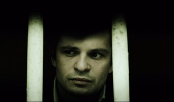 Movie still from “A Short Film About Killing” (1988), directed by Krzysztof Kieslowski – A person looking through a fence; Close Up shot, High angle