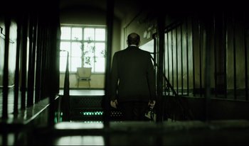 Movie still from “A Short Film About Killing” (1988), directed by Krzysztof Kieslowski – A man standing in front of a window; Wide shot, Low angle