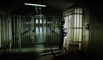 Movie still from “A Short Film About Killing” (1988), directed by Krzysztof Kieslowski – A man standing in front of a jail cell; Extreme Wide shot, High angle