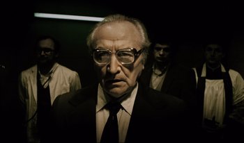 Movie still from “A Short Film About Killing” (1988), directed by Krzysztof Kieslowski – An old man wearing glasses and a suit; Medium shot, Low angle