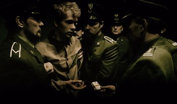 Movie still from “A Short Film About Killing” (1988), directed by Krzysztof Kieslowski – A group of men standing next to each other in a room; Medium shot, Over the shoulder angle