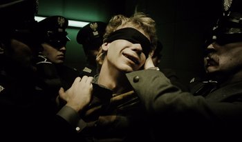Movie still from “A Short Film About Killing” (1988), directed by Krzysztof Kieslowski – A man blindfolded with a tie around his face; Close Up shot, High angle