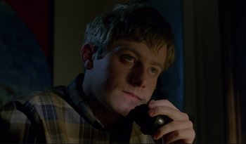 Movie still from “A Short Film About Love” (1988), directed by Krzysztof Kieslowski – A young man is talking on a cell phone; Close Up shot, Low angle