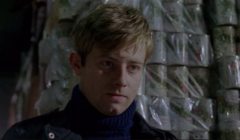 A young man with blonde hair wearing a black jacket