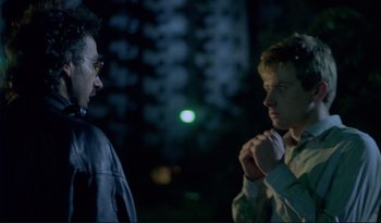 Movie still from “A Short Film About Love” (1988), directed by Krzysztof Kieslowski – Two people standing next to each other in the dark; Medium shot, Over the shoulder angle