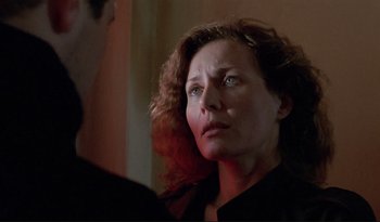 Movie still from “A Short Film About Love” (1988), directed by Krzysztof Kieslowski – A person with curly hair looking at the camera; Close Up shot, Over the shoulder angle